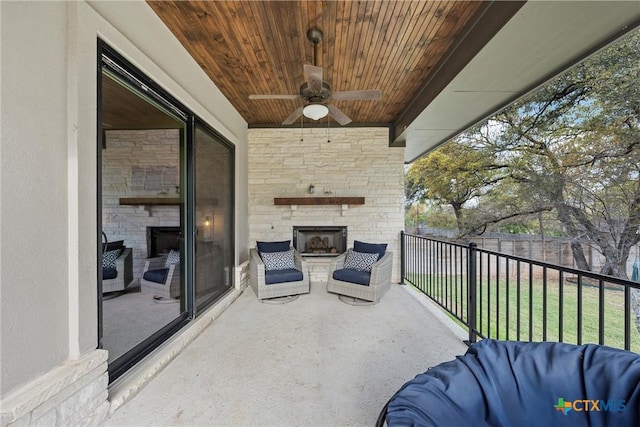 view of patio / terrace featuring ceiling fan and an outdoor stone fireplace