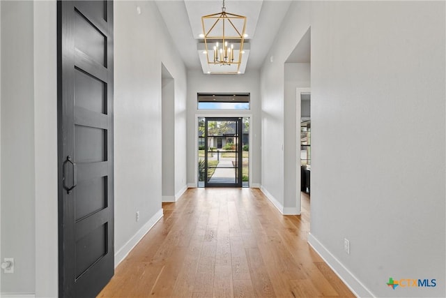 entrance foyer featuring light hardwood / wood-style floors and a notable chandelier