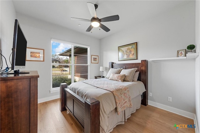 bedroom featuring ceiling fan, light hardwood / wood-style flooring, and multiple windows