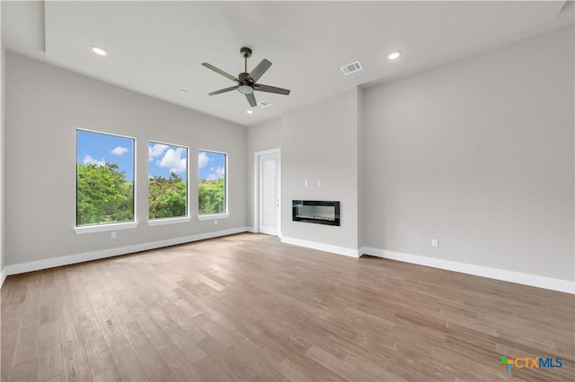 6846 Spring Branch Rd, Spring Branch, TX 78070 - unfurnished living room with a ceiling fan, wood finished floors, baseboards, a glass covered fireplace, and recessed lighting