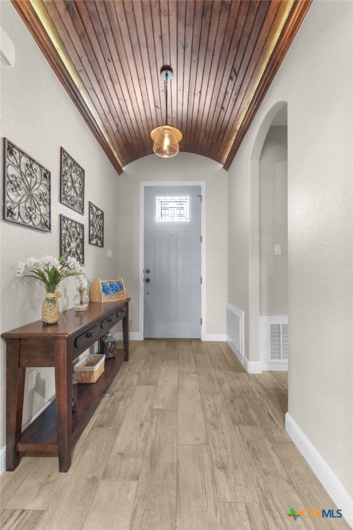 entryway featuring visible vents, baseboards, arched walkways, and vaulted ceiling