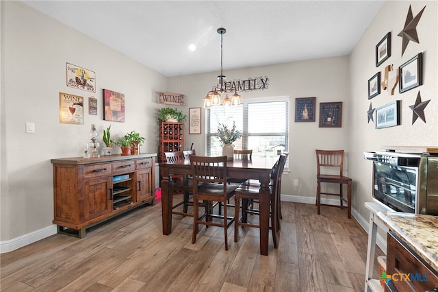 dining space featuring baseboards and light wood-type flooring