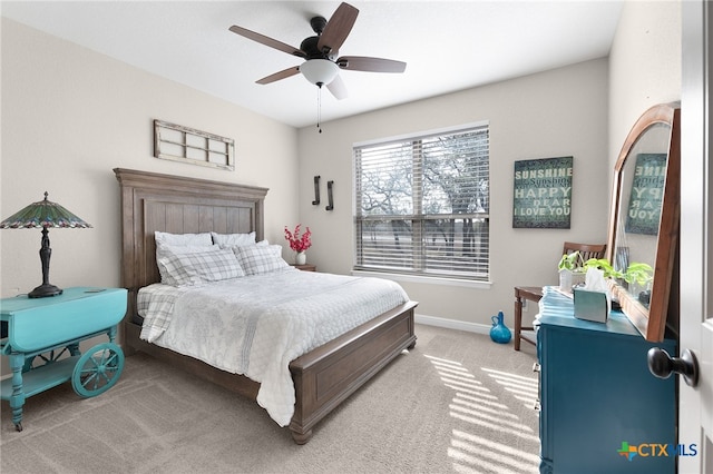 bedroom featuring light colored carpet, baseboards, and ceiling fan