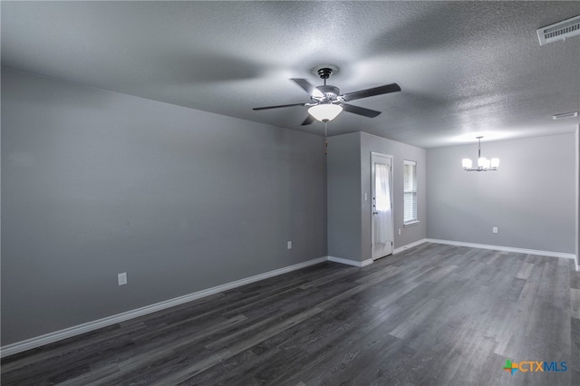 spare room featuring ceiling fan with notable chandelier, dark wood-type flooring, and a textured ceiling