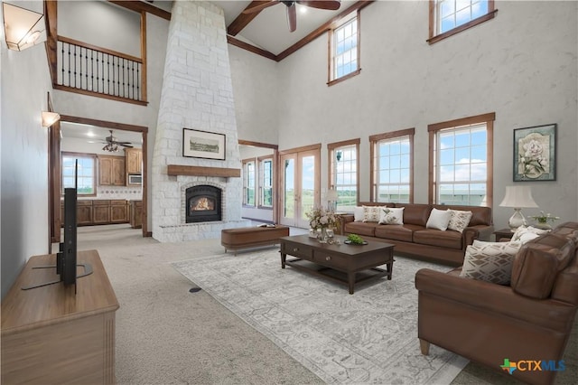 12491 Madison Ln, Justin, TX 76247 - living room with ceiling fan, high vaulted ceiling, a fireplace, light carpet, and beam ceiling