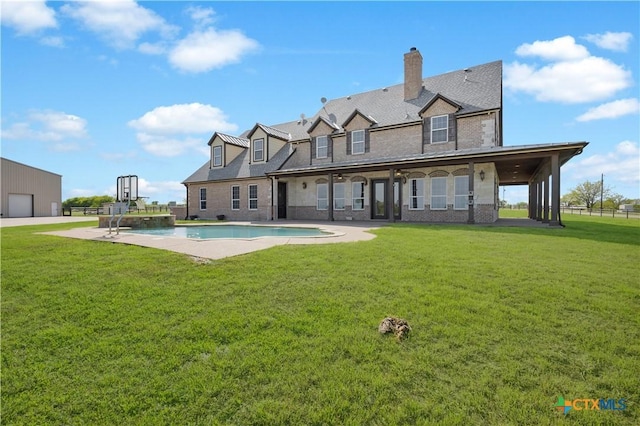 12491 Madison Ln, Justin, TX 76247 - back of property with a lawn, a pool with connected hot tub, a patio, and a chimney