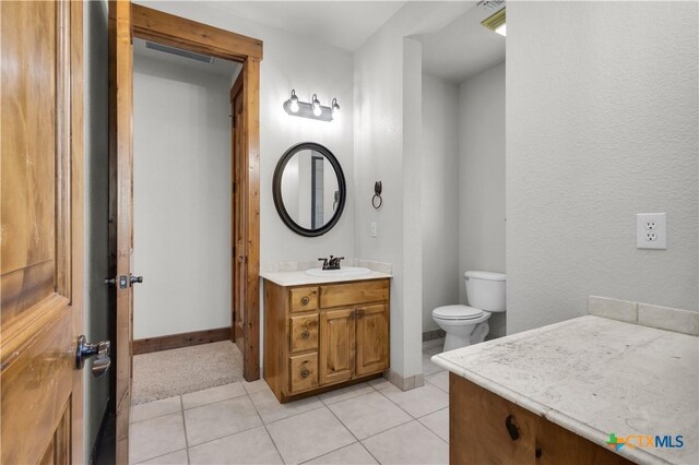 12491 Madison Ln, Justin, TX 76247 - bathroom with vanity, toilet, tile patterned flooring, and baseboards