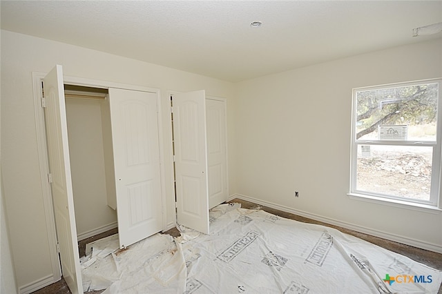 unfurnished bedroom with a closet and multiple windows