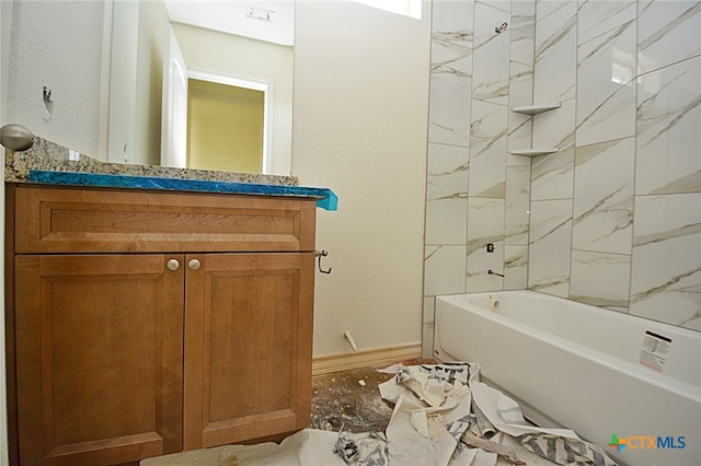 bathroom featuring vanity and tiled shower / bath