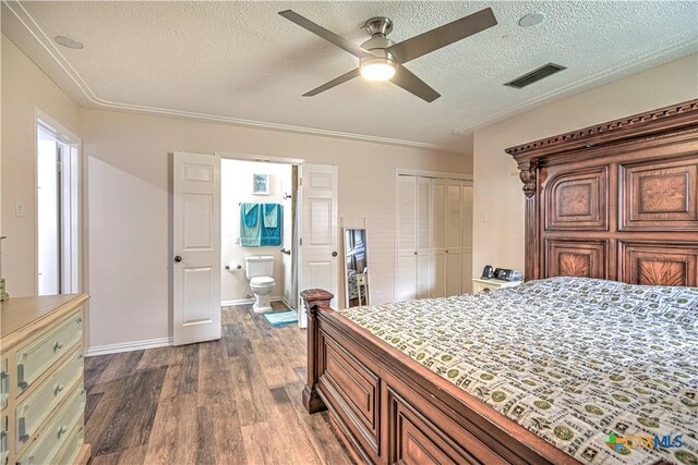 3117 Magnolia Blvd, Temple, TX 76502 - bedroom featuring dark wood finished floors, a textured ceiling, ensuite bath, a closet, and ceiling fan