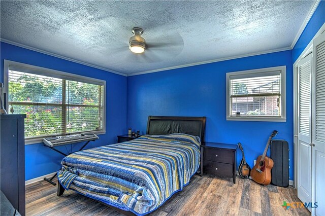 3117 Magnolia Blvd, Temple, TX 76502 - bedroom featuring wood finished floors, a closet, crown molding, a textured ceiling, and ceiling fan