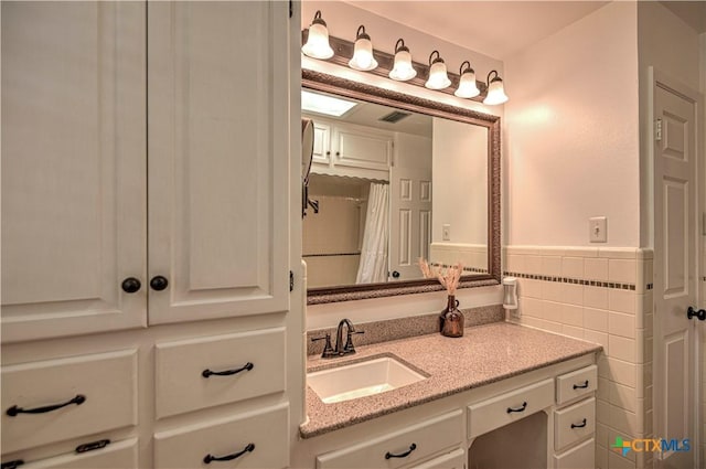 3117 Magnolia Blvd, Temple, TX 76502 - full bathroom featuring vanity, tile walls, a wainscoted wall, and a shower with curtain