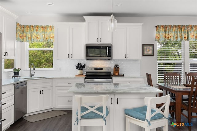 127 Diamond Head Dr, Bastrop, TX 78602 - kitchen featuring appliances with stainless steel finishes, a sink, white cabinetry, backsplash, and plenty of natural light