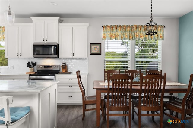 127 Diamond Head Dr, Bastrop, TX 78602 - kitchen featuring stainless steel microwave, electric range, dark wood-type flooring, tasteful backsplash, and a chandelier