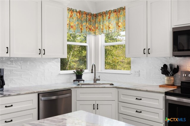 127 Diamond Head Dr, Bastrop, TX 78602 - kitchen featuring stainless steel appliances, a sink, white cabinets, and backsplash