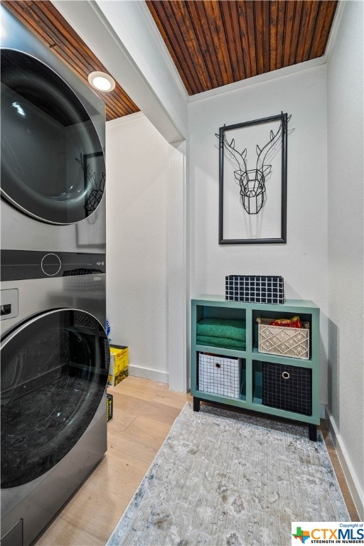 laundry area with ornamental molding, wood ceiling, hardwood / wood-style floors, and stacked washer and dryer