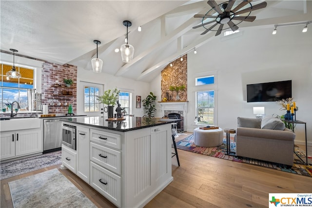 kitchen with white cabinetry, sink, hanging light fixtures, a wealth of natural light, and a kitchen island