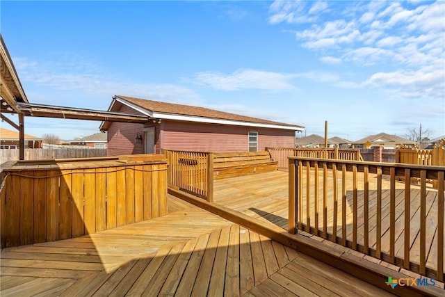 wooden deck featuring a residential view and a fenced backyard