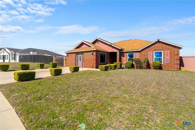 single story home with brick siding, a front lawn, and fence