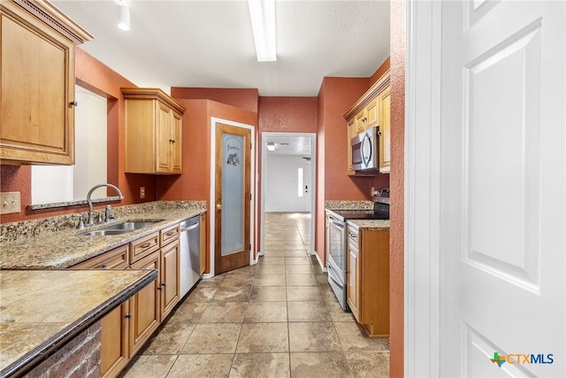 kitchen with light tile patterned flooring, appliances with stainless steel finishes, and a sink