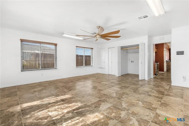 interior space with visible vents, baseboards, and ceiling fan