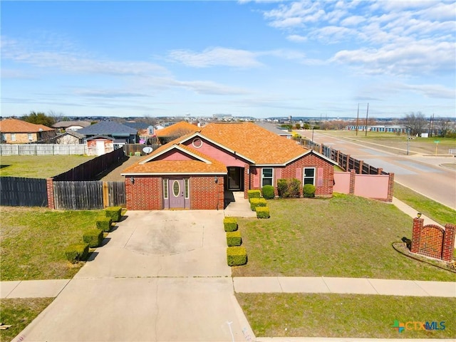 single story home featuring brick siding, concrete driveway, a front yard, and fence