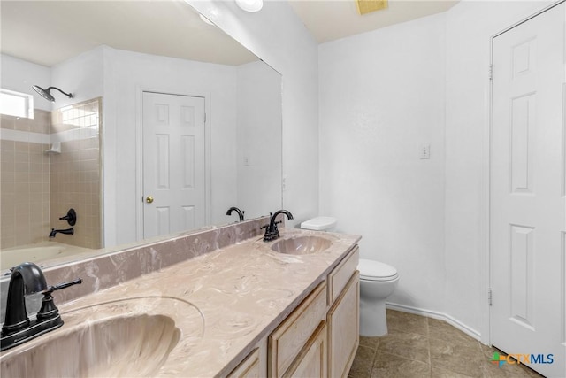 full bathroom featuring double vanity, tile patterned flooring, toilet, and a sink