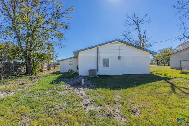 back of property featuring cooling unit and a yard