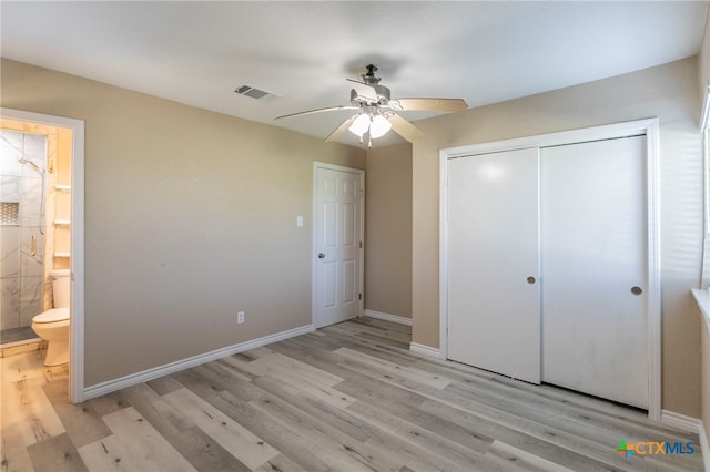 unfurnished bedroom featuring a closet, ensuite bathroom, light hardwood / wood-style flooring, and ceiling fan