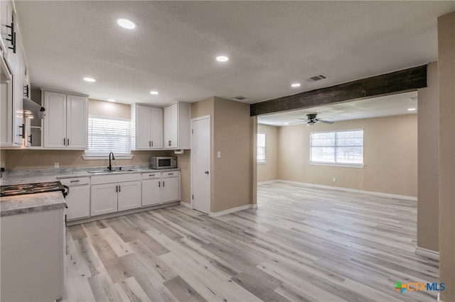 kitchen featuring sink, light hardwood / wood-style flooring, ceiling fan, beam ceiling, and white cabinetry