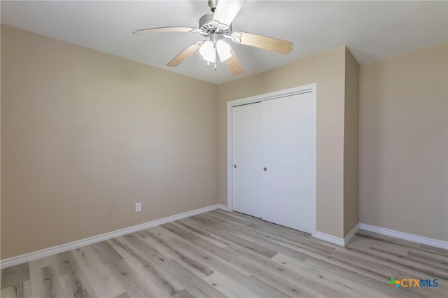 unfurnished bedroom featuring ceiling fan, a closet, and light hardwood / wood-style flooring