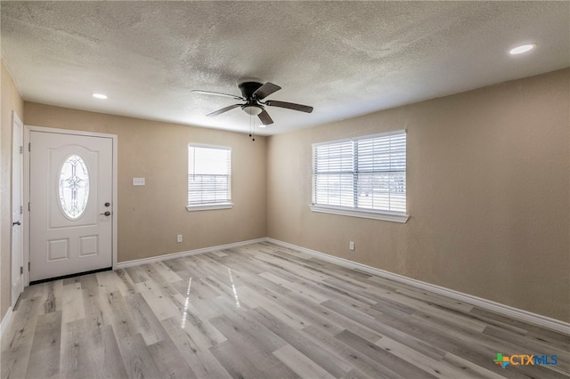 entryway featuring ceiling fan, light wood-type flooring, and a textured ceiling