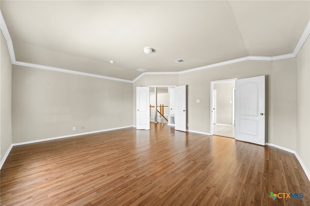 unfurnished room with lofted ceiling, wood-type flooring, and crown molding