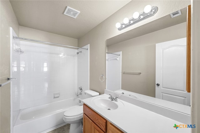 full bathroom featuring vanity, toilet, a textured ceiling, and tiled shower / bath combo