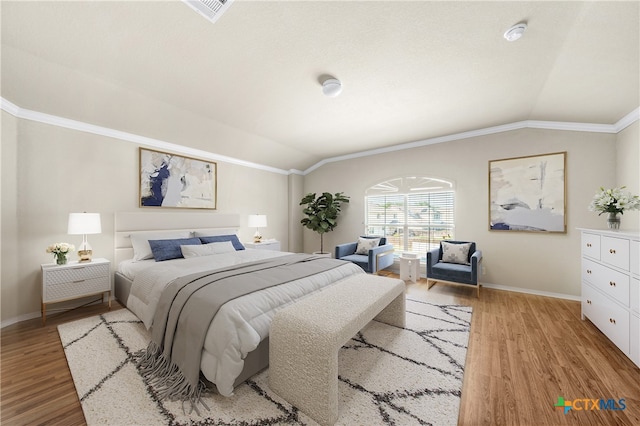 bedroom featuring light hardwood / wood-style floors, lofted ceiling, and crown molding