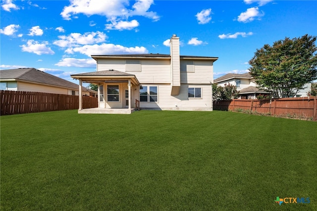 rear view of house with a patio and a yard