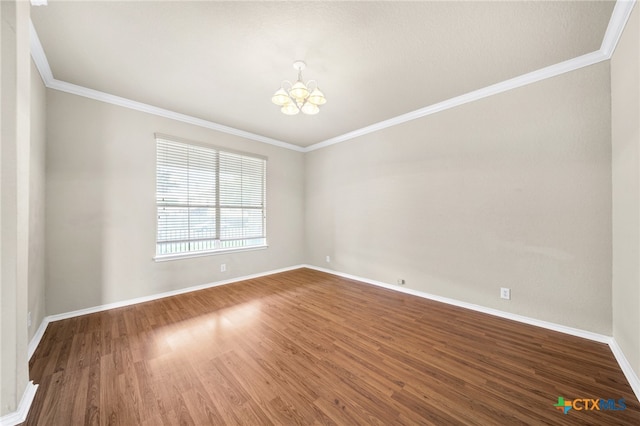 empty room featuring wood-type flooring, a chandelier, and crown molding