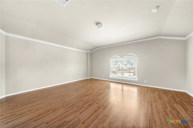 spare room featuring hardwood / wood-style floors, lofted ceiling, and crown molding