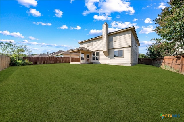 rear view of house with a yard and a patio area