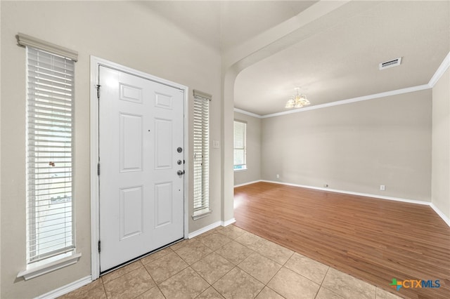 entrance foyer with light hardwood / wood-style flooring and crown molding