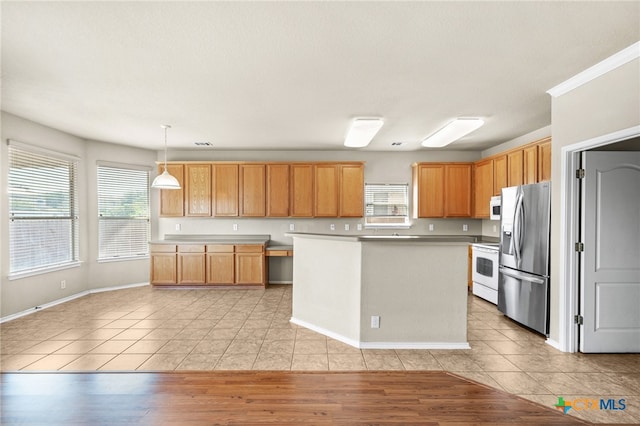 kitchen with pendant lighting, white appliances, a healthy amount of sunlight, and light hardwood / wood-style flooring