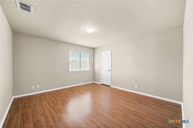 empty room featuring hardwood / wood-style floors and a textured ceiling