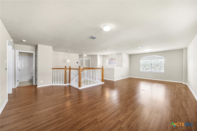 spare room with dark hardwood / wood-style flooring and a textured ceiling