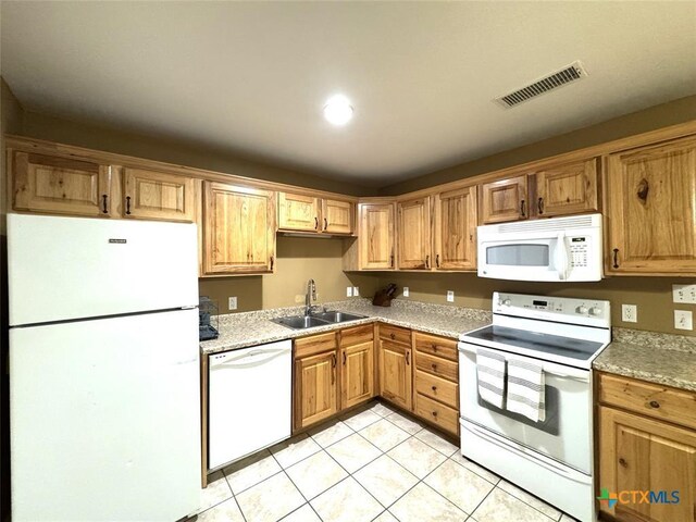305 Ivy Ave, Luling, TX 78648 - kitchen with white appliances, a sink, light tile patterned floors, and light countertops