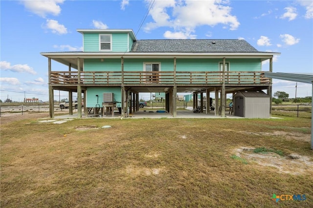 back of property featuring a storage shed, fence, a lawn, and an outdoor structure