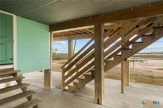 view of patio featuring entry steps, stairway, and fence