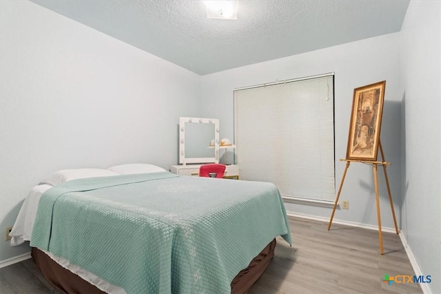 4313 Lone Star Trl, Temple, TX 76502 - bedroom with wood finished floors, baseboards, and a textured ceiling
