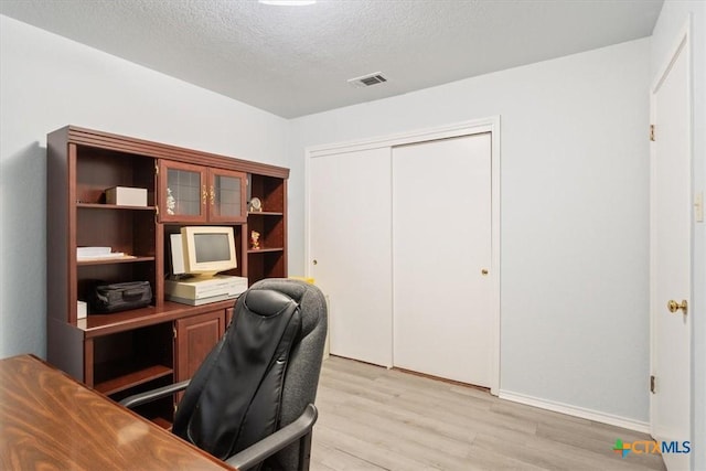 4313 Lone Star Trl, Temple, TX 76502 - home office with light wood-type flooring, a textured ceiling, and baseboards