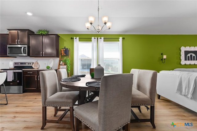 dining area featuring light hardwood / wood-style floors and a notable chandelier