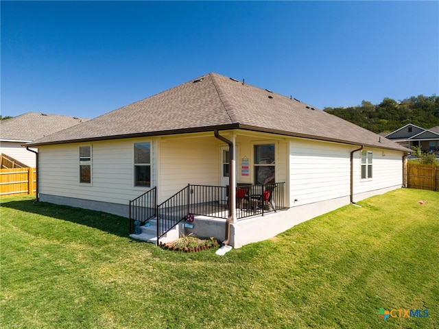 back of house with a lawn and a patio